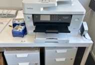1531926 Table with printers, laminators and filing cabinets