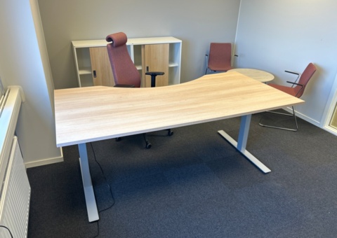 Office workplace with electric desk and various furniture