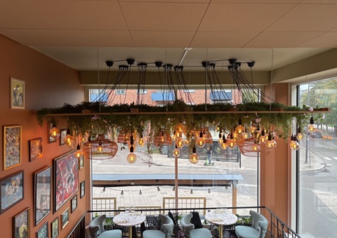 Lamp installation with wooden frame, lighting and artificial flowers