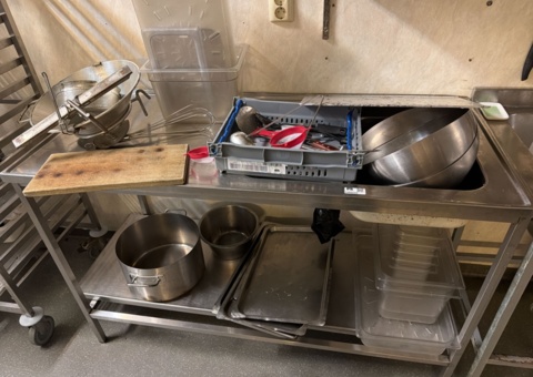 Stainless steel sink with cooking utensils, bowls and canteens