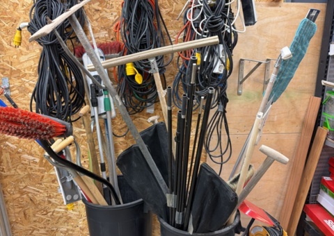 Collection of extension cords, shovels and hand tools