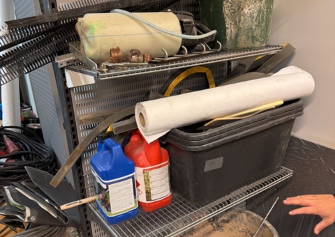 Shelves with consumables, work clothes and concrete