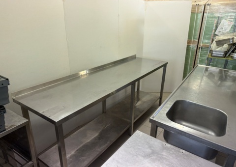Stainless steel workbench with lower shelf, folded back edge. Approx. 230x65x90 cm