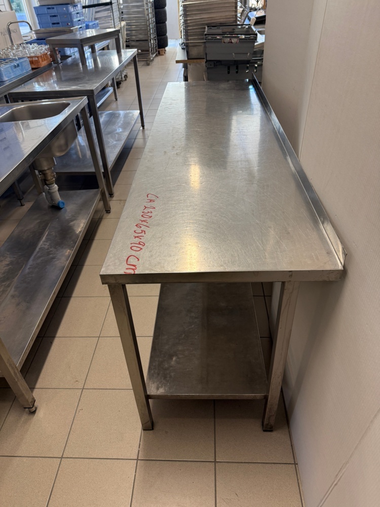 1141794-2 Stainless steel workbench with lower shelf, folded back edge. Approx. 230x65x90 cm
