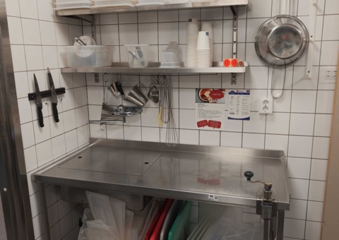 Workbench with stainless steel sink and kitchen utensils