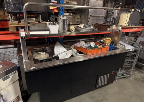 Salad counter with various kitchen utensils/accessories