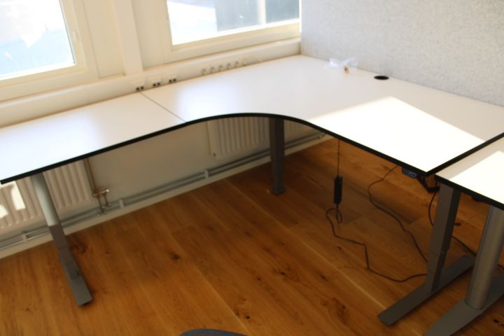 637687-5 Elektiskt höj/sänkbart skrivbord i vinkel EFG med skiljevägg, kontorsstol Kinnarps, bokhylla