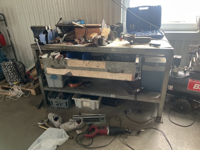1469591-1 Workshop bench with mixed hand and power tools.