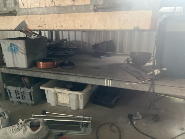1469591-3 Workshop bench with mixed hand and power tools.