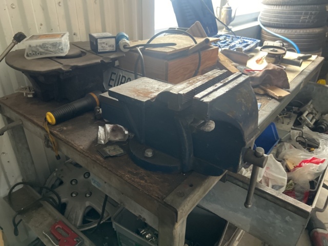 1469591-6 Workshop bench with mixed hand and power tools.