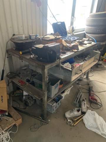 1469591-7 Workshop bench with mixed hand and power tools.